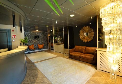 a lobby with a couch and chandeliers at Hotel & SPA Niunit in Ordino