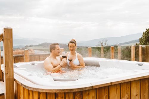 a man and a woman sitting in a hot tub at Almhaus Rinner in Greith
