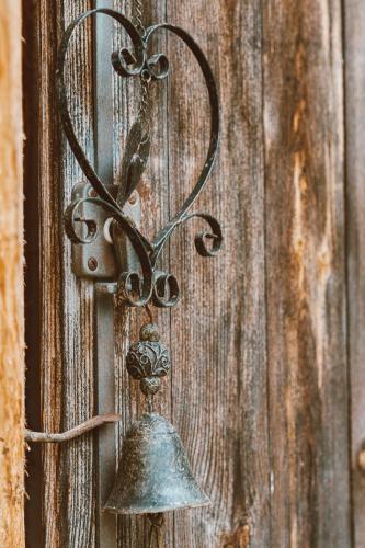 a metal bell hanging on a wooden door at Almhaus Rinner in Greith