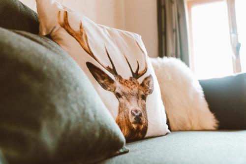 a deer head on a pillow on a couch at Almhaus Rinner in Greith