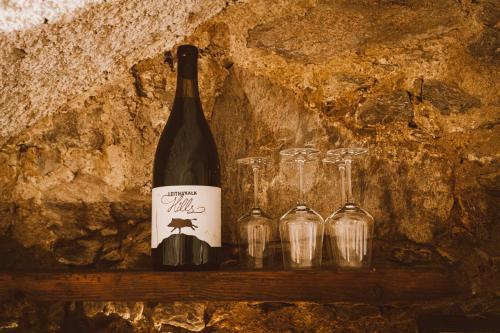 a bottle of wine sitting on a shelf with glasses at Almhaus Rinner in Greith