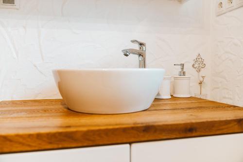 a white sink on a wooden counter in a bathroom at Almhaus Rinner in Greith