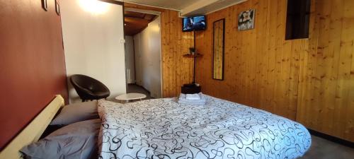 1 dormitorio con 1 cama en una habitación con paredes de madera en Studio hypercentre à 2 pas de la gare. Appart n°3, en Agen