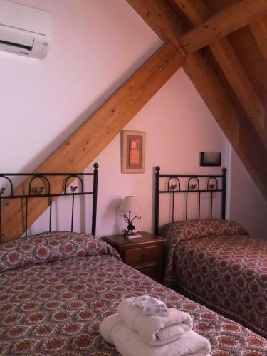 アロヨ・フリオにあるNoelia Cazorla sierraのベッドルーム(ベッド2台付)が備わる屋根裏部屋です。