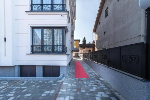 a red carpet on a sidewalk next to a building at Daisy resort in Novi Sad