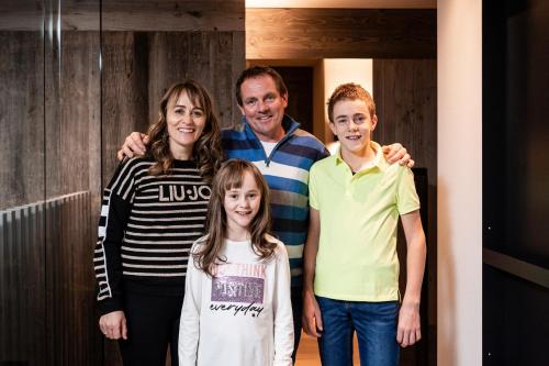 a family posing for a picture in a hallway at Surega - Idyllic Farmhouse in San Cassiano