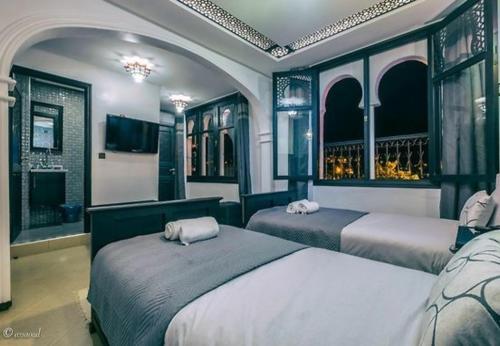 - une chambre avec 2 lits et une télévision dans l'établissement HOTEL PEDRO, à Chefchaouen