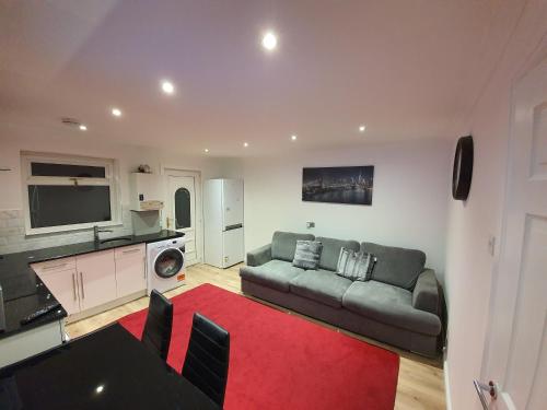 a living room with a couch and a red rug at Modern house close to Glasgow Green in Glasgow