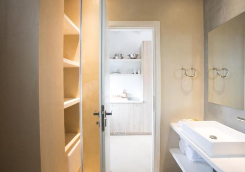 a bathroom with a sink and a mirror and a door at Princess Of Naxos in Naxos Chora