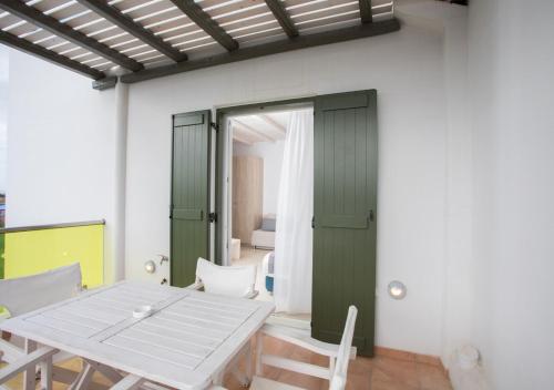 a dining room with a white table and chairs at Princess Of Naxos in Naxos Chora