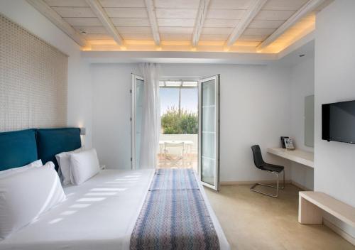 a hotel room with a bed and a tv at Princess Of Naxos in Naxos Chora
