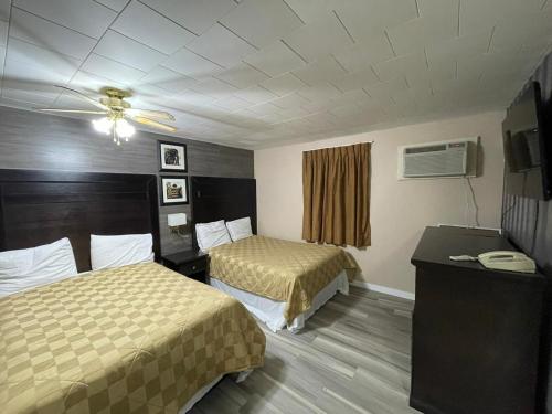 a hotel room with two beds and a ceiling fan at Valley Motor Lodge in Minnedosa