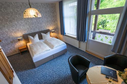 a hotel room with a bed and a table and chairs at Pension Schweizer Hof in Wernigerode