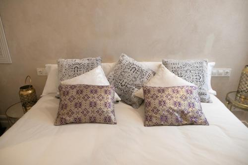 a white bed with four pillows on it at innCádizPalacio Conde Casa-Brunet in Cádiz