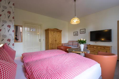 a bedroom with a bed with a pink and white blanket at Pension Schweizer Hof in Wernigerode