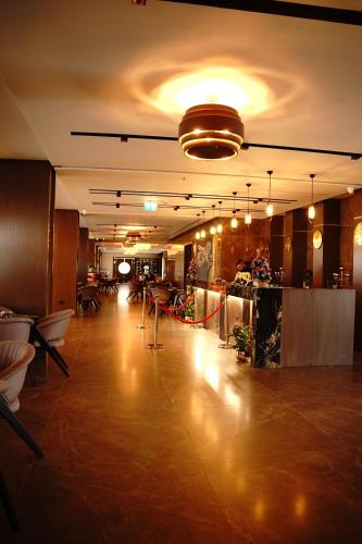 ein Restaurant mit einer großen Lobby mit Tischen und Stühlen in der Unterkunft Deluxe Resort and SPA in Shkodra