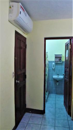 a bathroom with a toilet and a sink and a door at AC Room 4 Persons Hospedaje Don Wilfredo in San Juan del Sur