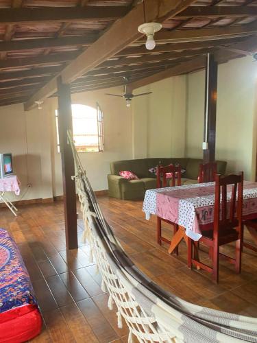 a hammock in a living room with a table and a couch at Apartamento rústico in Cabo Frio