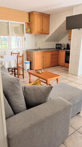 a living room with a couch and a table at APARTAMENTOS TURÍSTICOS CASA SANDRA in Sanxenxo