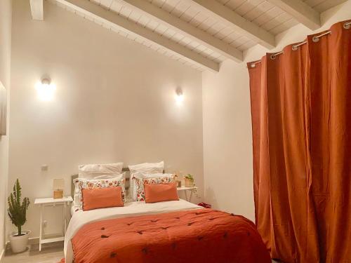 a bedroom with a large bed with orange curtains at villa Luberon in Saint-Saturnin-les-Apt