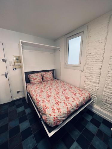 un lit dans une chambre avec une fenêtre dans l'établissement Studio Centre Historique Toulouse Saint Etienne, Carmes, à Toulouse