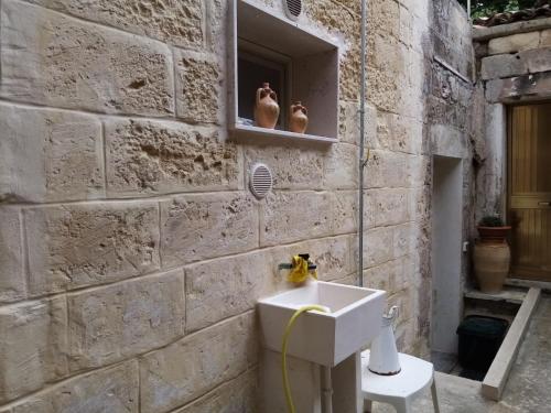 a bathroom with a sink in a stone wall at La Maison d'Eugenia in Casamassella