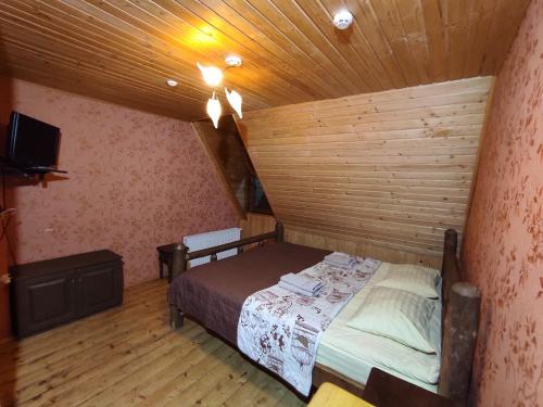 a small room with a bed in a wooden ceiling at Вотавілю Драгобрат in Dragobrat