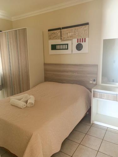 1 dormitorio con 1 cama con toallas en Apartamentos 800 metros do Mar - Residencial Vieira, en Florianópolis