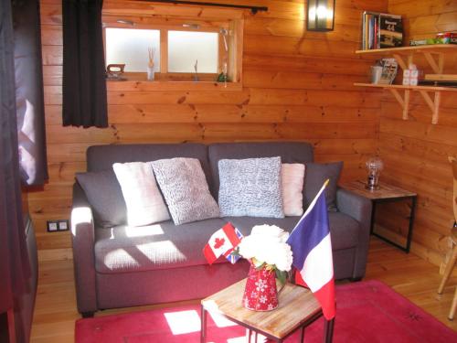 a living room with a couch and a table at bord de mer, chalet en bois avec tandem in Lion-sur-Mer