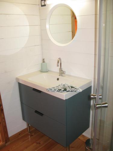 une salle de bain avec un lavabo et un miroir dans l'établissement bord de mer, chalet en bois avec tandem, à Lion-sur-Mer