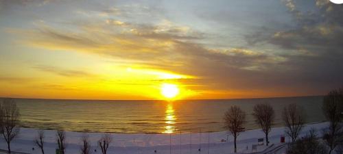 a sunset over the ocean with the sun setting at Giorgos Apartments Sea View in Olympiaki Akti