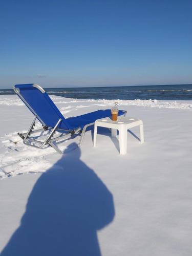a blue chair and a table on the beach at Giorgos Apartments Sea View in Olympiaki Akti