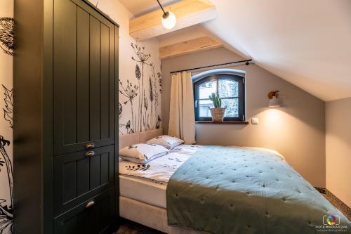 ein kleines Schlafzimmer mit einem Bett und einem Fenster in der Unterkunft Apartamenty Stacja Huta in Szklarska Poręba