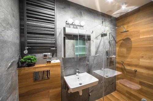 ein Bad mit einem Waschbecken und einem Spiegel in der Unterkunft Cracowapart Ignacio A in Krakau