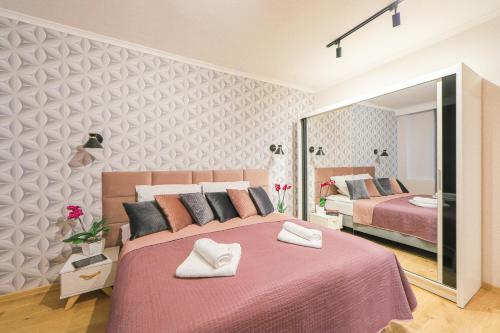 1 Schlafzimmer mit 2 Betten und einem großen Spiegel in der Unterkunft Cracowapart Ignacio A in Krakau