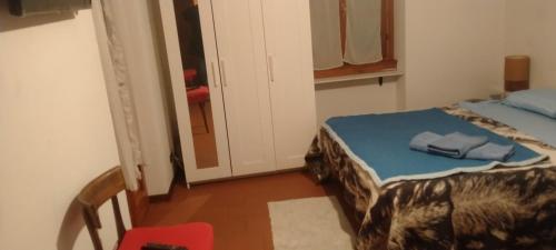 una piccola camera con letto e sedia rossa di Mono LOCALE a Carenno