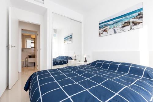 a white bedroom with a blue comforter on a bed at Fortuna -7/1 in Rojales