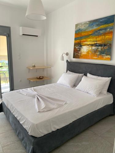 Una cama en un dormitorio con un cuadro en la pared. en A.P Seaside, en Artemida