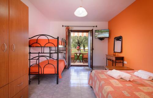 a bedroom with two beds and a door to a patio at Studios Anna in Vourvourou