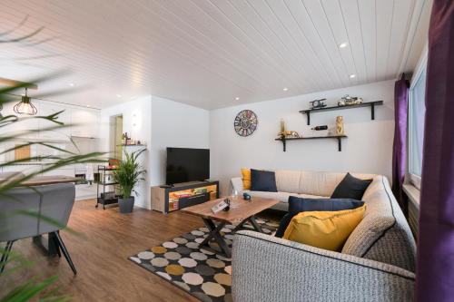 a living room with a couch and a table at Spirit Apartments - Balkon - Bergsicht - Parkplatz in Engelberg