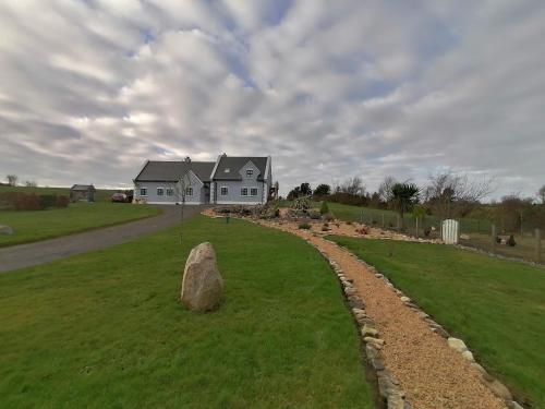 a house with a rock in the middle of a yard at Self catering upstairs apartment at Tradcottage in Sligo