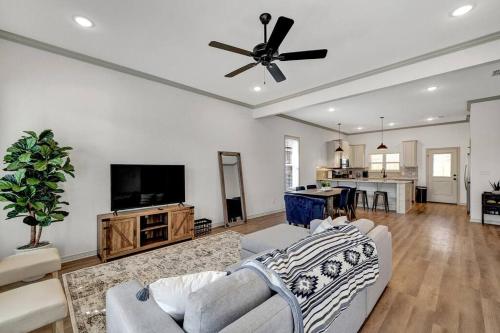 a living room with a couch and a ceiling fan at Alamo Luxury Living up to 11 in Tyler