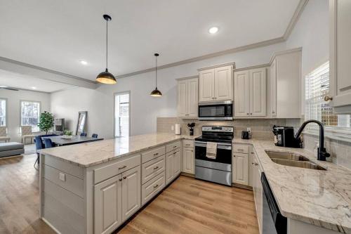 a kitchen with white cabinets and marble counter tops at Alamo Luxury Living up to 11 in Tyler