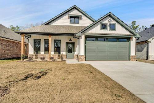 a house with a green garage door in a yard at Alamo Luxury Living up to 11 in Tyler