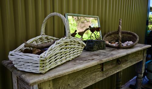 a table with two baskets and a mirror on it at Kākā Ridge Retreat Luxury Cottage in Tawharanui