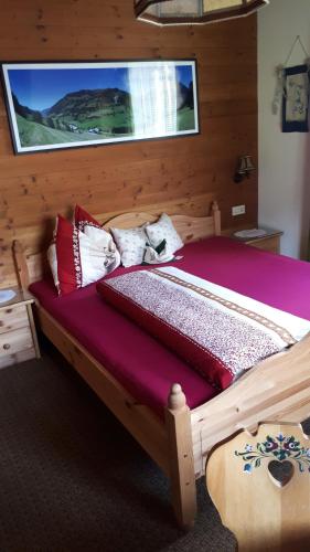 a wooden bed with pillows on it in a room at Bio-Bauernhof Schiederhof in Fusch an der Glocknerstraße
