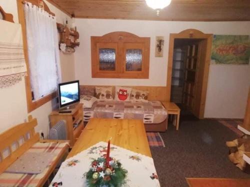 a living room with a table and a television at Chata Lenka in Štrba