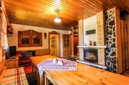 a living room with a table and a fireplace at Chata Lenka in Štrba