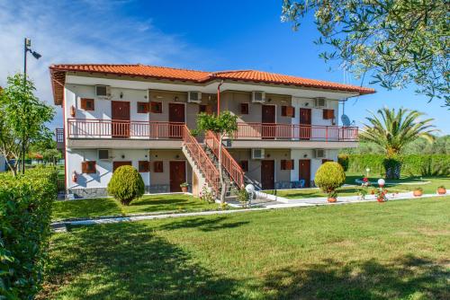 a house with a lawn in front of it at Studios Anna in Vourvourou