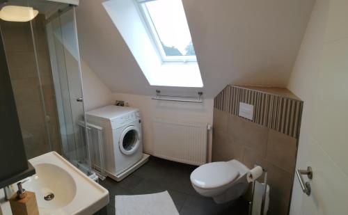 een badkamer met een wasmachine en een wastafel bij Ferienwohnung Schleeff in Elsfleth